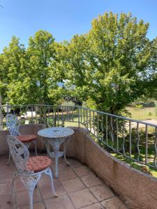 a patio with a table and chairs and trees at La Bastide de Villecroze in Villecroze