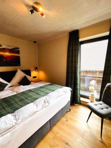 a bedroom with a bed and a chair and a window at Hoisler's Appartements in Ehrwald