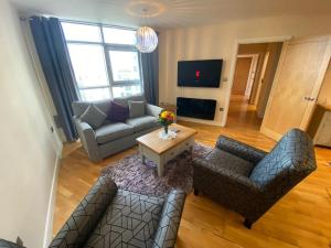 una sala de estar con un sofá y una mesa en *Modern 2 bed apartment in the heart of Cardiff*, en Cardiff