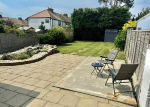 a patio with two chairs and a table in a yard at Betty's Bungalow in Lancing +4 photos