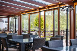a restaurant with tables and chairs and windows at Hotel Dziki Potok Karpacz in Karpacz +108 photos