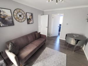 een woonkamer met een bank en een tafel bij Abernethy Quay - Swansea Marina in Swansea