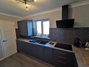 een keuken met een aanrecht met een wastafel en een raam bij Abernethy Quay - Swansea Marina in Swansea