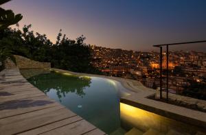 モーディカにあるCASA TALIA - Roomsの夜の街の景色を望むプール
