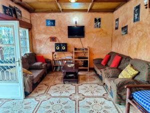 a living room with couches and a flat screen tv at Amahoro Guest House in Ruhengeri