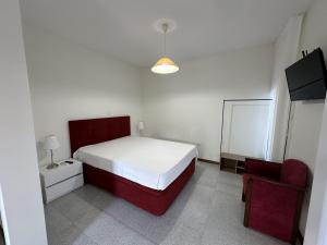 a bedroom with a red bed and a mirror at Quinta da Touça in Baião