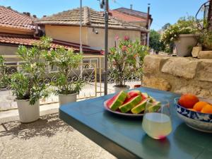 Una mesa azul con un plato de fruta encima. en House Vesela, en Balchik