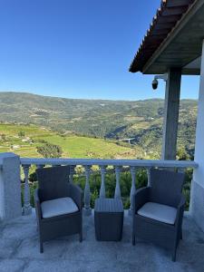two chairs sitting on a balcony with a view at Quinta da Touça in Baião