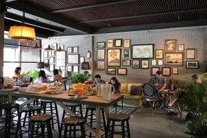 a group of people sitting at tables in a restaurant at Heyyyy Bangkok in Bang Kapi