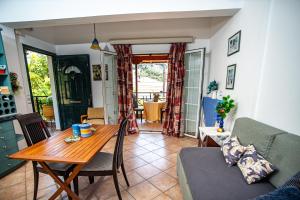 a living room with a table and a couch at THOLETO APARTMENTS in Agios Gordios