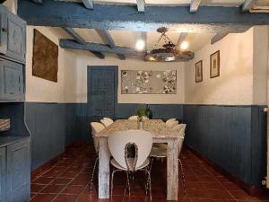 a dining room with a table and a white chair at El mirador del río de Arnedillo in Arnedillo