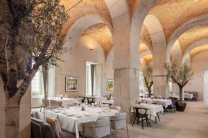 a restaurant with tables and chairs in a room with arches at The Lince Santa Clara in Vila do Conde