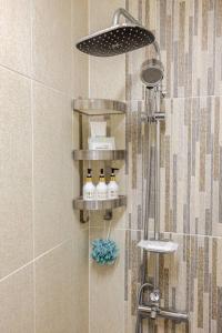 a bathroom with a shower with three bottles of soap at All in one Guesthouse in Incheon +57 photos