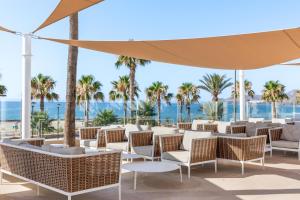 a patio at the beach with chairs and an umbrella at Best Club Vacaciones Pueblo Indalo in Mojácar +37 photos