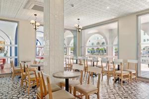 a dining room with tables and chairs and windows at Best Club Vacaciones Pueblo Indalo in Mojácar