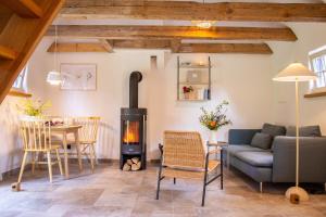 - un salon avec un canapé et un poêle à bois dans l'établissement Ruhiger Rückzugsort mit Kamin & Garten, für Paare, à Häven 17 autres photos