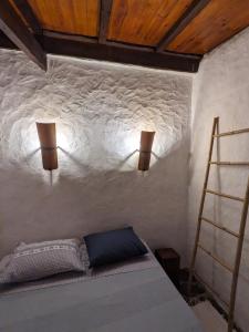 a bedroom with a bed and two lights on the wall at Riverlake House - frente ao lago e com jardim in Vila de Rei