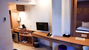 a room with a desk with a television and a bed at Asialink Easy by Prasanthi in Batam Center