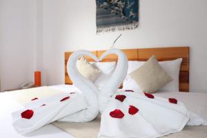 due asciugamani a forma di cigno seduti su un letto di Fenix Hotel Machupicchu a Machu Picchu