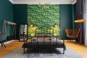 a bedroom with a green wall with a bed and a chair at Heart of City in Budapest