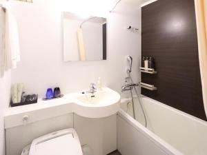 a bathroom with a sink and a toilet and a bath tub at Dormy Inn Premium Shibuya-jingumae in Tokyo