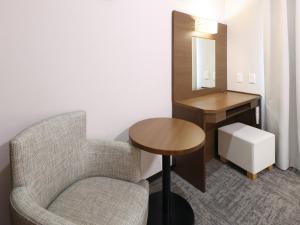 a room with a chair and a table and a mirror at Dormy Inn Premium Shibuya-jingumae in Tokyo