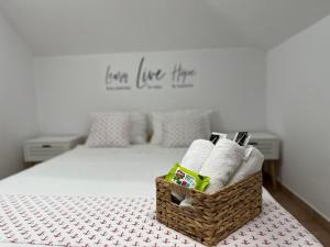 Un dormitorio con una cama con una cesta de toallas. en Casa FM, en Vama Veche