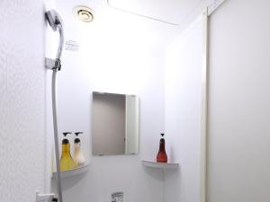 a bathroom with a shower with bottles on shelves at Dormy Inn Premium Shibuya-jingumae in Tokyo