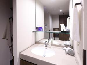 a bathroom with a sink and a mirror at Dormy Inn Premium Shibuya-jingumae in Tokyo