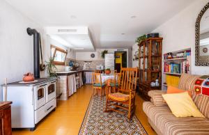 a kitchen and living room with a couch and a table at La Puerta Verde in Mataelpino