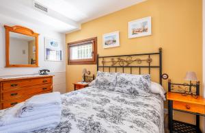 a bedroom with a bed and a dresser and a mirror at La Puerta Verde in Mataelpino