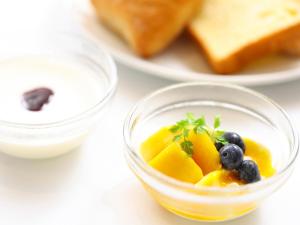 a bowl of fruit with blueberries and bread on a plate at Dormy Inn Premium Shibuya-jingumae in Tokyo