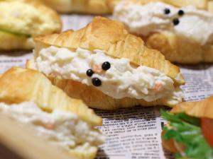 a close up of a sandwich with cheese and black olives at Dormy Inn Premium Shibuya-jingumae in Tokyo