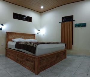 a bedroom with a large wooden bed in a room at Sudana Homestay in Ubud City in Ubud