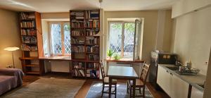a kitchen with a table and a book shelf with books at Nalewki Studio in the heart of Warsaw in Warsaw