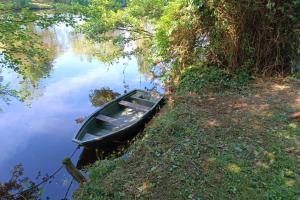 a small boat sitting on the side of a river at Le Florin d'Or - Bords de Creuse in Saint-Gaultier