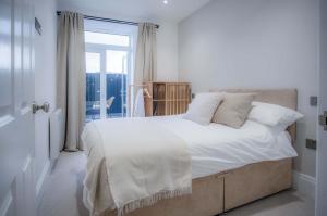 ein Schlafzimmer mit einem großen Bett mit weißen Laken und Kissen in der Unterkunft No 4 Croft House - Luxury 2 Bed Apartment - Tenby in Tenby