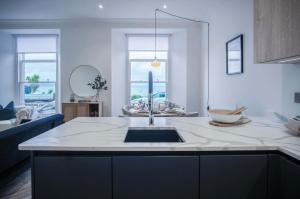 eine Küche mit Spüle und Arbeitsplatte in der Unterkunft No 4 Croft House - Luxury 2 Bed Apartment - Tenby in Tenby + 56 Fotos