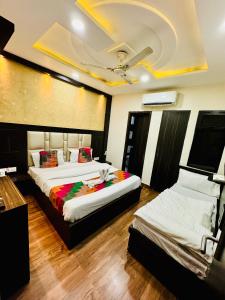 a bedroom with two beds and a ceiling at Hotel Kabir Residency in Amritsar