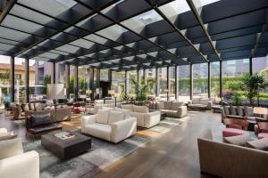 a lobby with couches and chairs and windows at Hilton Lake Como in Como