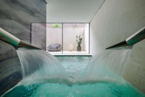 a pool of water in a room with a waterfall at Hilton Lake Como in Como