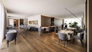 a restaurant with tables and chairs in a room at Hilton Lake Como in Como
