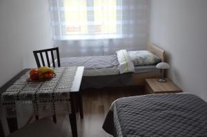 a room with two beds and a table with fruit on it at Apartament Szczecin Pomorzany in Szczecin