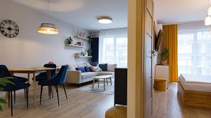 a living room with a couch and a table at VacationClub - Sagaris Apartament 14 in Dziwnów