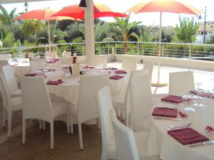 a restaurant with white tables and chairs and umbrellas at Ganimede Hotel in Sperlonga