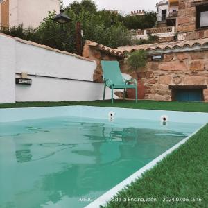 a blue chair sitting in a pool of water at Casa María Rosa in Baños de la Encina