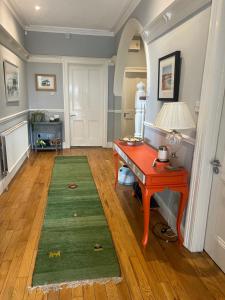 a room with a desk and a green rug at Hillrise B&B in Portrush