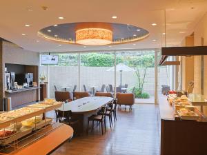 a restaurant with a table and chairs and a cafeteria at Dormy Inn Premium Shibuya-jingumae in Tokyo