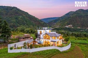 an aerial view of a house with mountains in the background at StayVista at The Oakridge Lavish 4 BHK villa in Dharamshala with Jacuzzi in Chamba