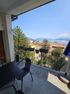 a patio with a table and chairs on a balcony at Lake View in Meina